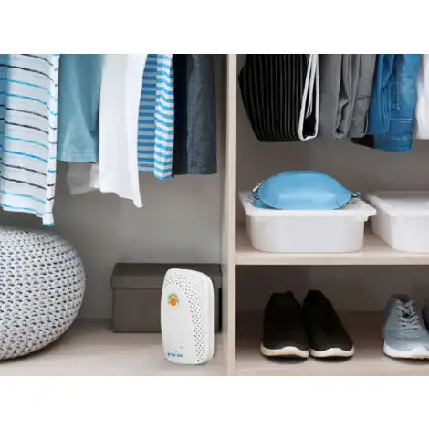 Mini déshumidificateur à gel de silice posé dans une armoire, utilisé pour protéger vêtements et chaussures de l’humidité.